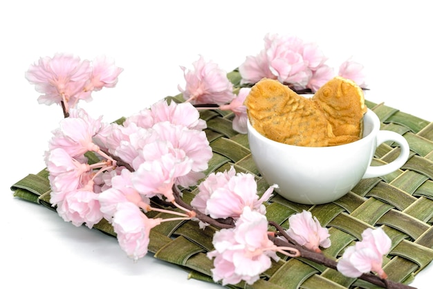 Taiyaki cakes in coffee cup with cherry blossomJapanese confectionery