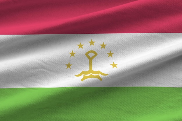 Фото Флаг таджикистана с большими складками развевается крупным планом под студийным светом в помещении официальные символы и цвета в баннере
