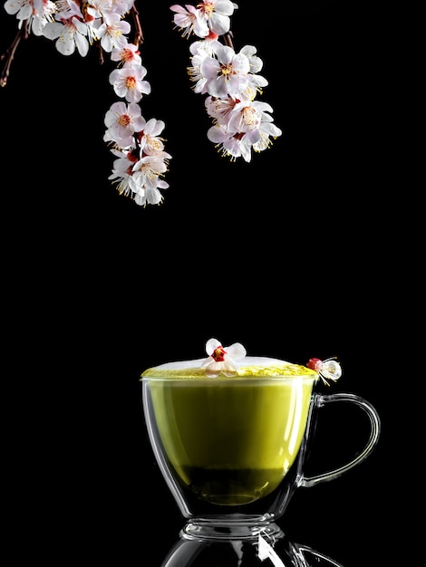 tak van bloeiende kersen en een kopje matcha groene thee