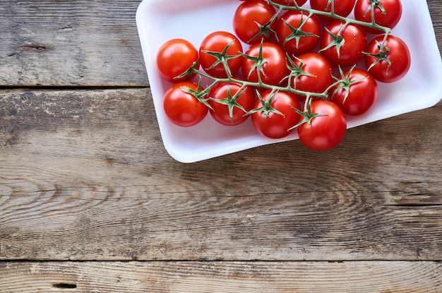 Tak van rijpe cherrytomaten in plastic verpakkingen