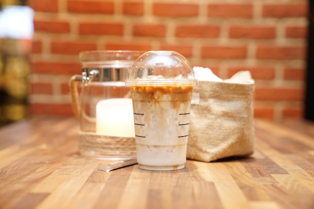 Photo take away latte with brick on the wood table