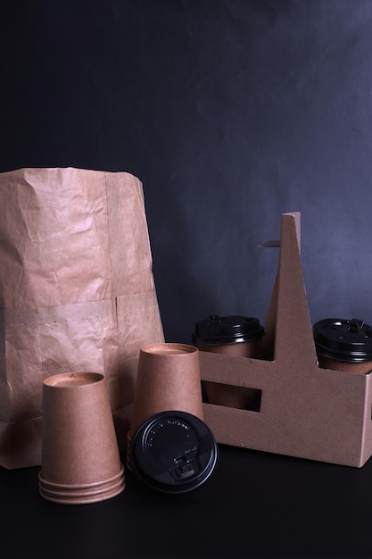 Take away paper coffee cup with lunch bag on dark background