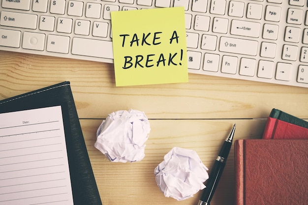 Take a break text on yellow paper on top of computer keyboard