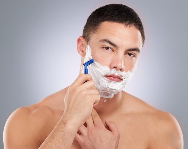 Take care of the man it the mirror Shot of a handsome young man shaving his facial hair