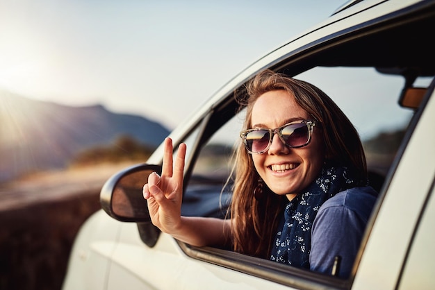 Take it easy Portrait of a young woman showing a piece sign while sitting in her car