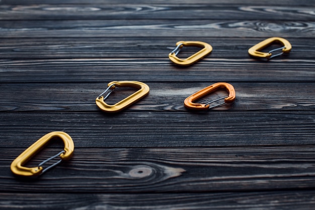 Take it for you extreme weekend activities. Isolated climbing equipment. Parts of carabiners lying on the wooden table.