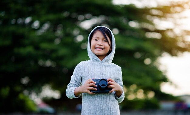 ミラーレスカメラで写真を撮る 少し自然写真の練習をする女の子