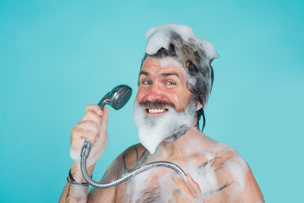 Take a shower man with foam on head shampoo body washing bearded man washing hair hair care spa