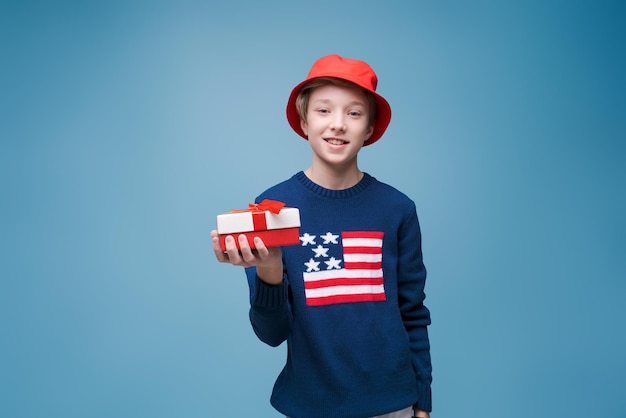 Take your present portrait of hipster guy in blue us flag sweater with red panama hat ready to throw...