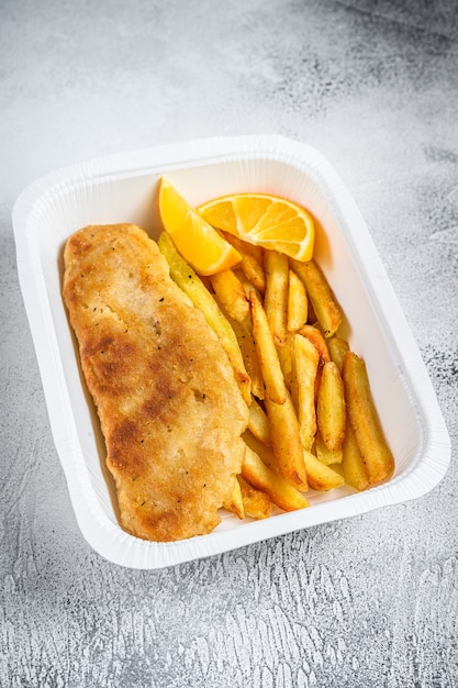 Takeaway box Fish and chips schotel met frietjes. Witte achtergrond. Bovenaanzicht.