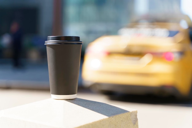 Takeaway coffee in a paper cup Hot drink to go on the background of a busy city street Paper