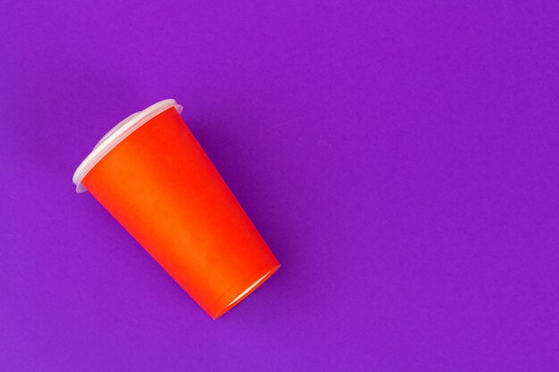 Takeaway cup of coffee on bright colored 