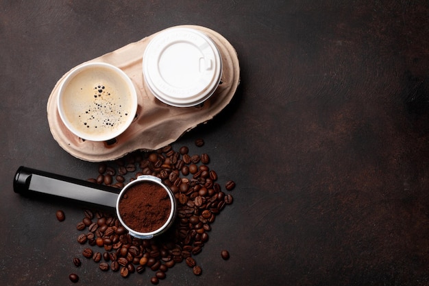 Takeaway cups roasted coffee beans and ground coffee in holder