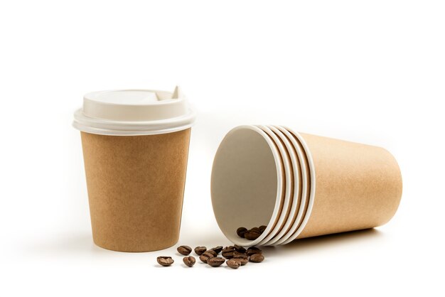 Takeaway paper cups and coffee beans isolated on white background.