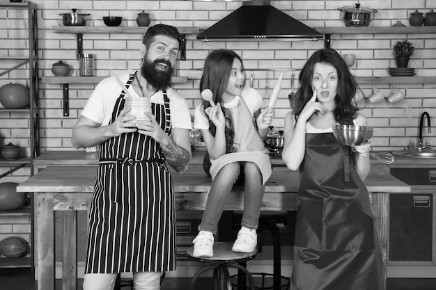 Taken en plichten Kind met ouders koken in de keuken Familie bereiden eten Kookteam Koken met liefde Verjaardagstaart bereiden Vriendelijk gezin Moeder vader en dochter samen koken