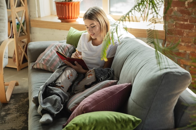 Foto taken krijgen. blanke vrouw, freelancer tijdens het werk in thuiskantoor tijdens quarantaine. jonge zakenvrouw thuis, zelf geïsoleerd. gadgets gebruiken. werken op afstand, preventie van verspreiding van coronavirus.