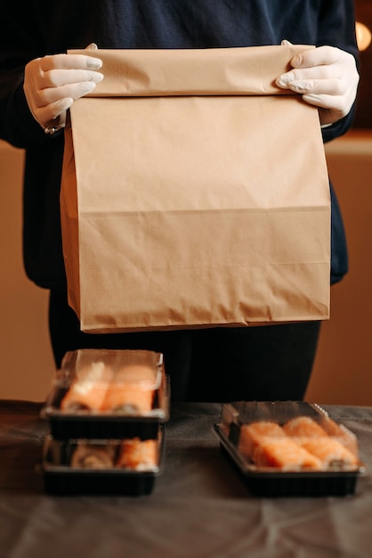 Photo takeout food concept. girl holding cardboard bags with food in front of the camera