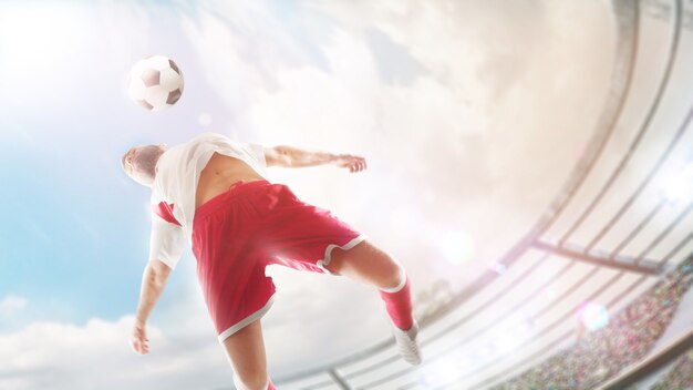 Taking the ball on the chest in football. Close ups. The soccer player is jumping to hitting soccer ball with chest. Sport action. Fish eye. Sunny day