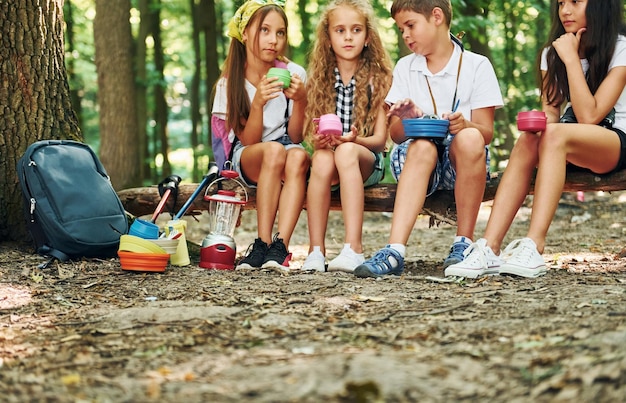 Photo taking a break kids strolling in the forest with travel equipment