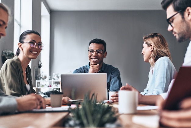 Taking care of business. Group of young modern people in smart casual wear discussing business while working in the creative office