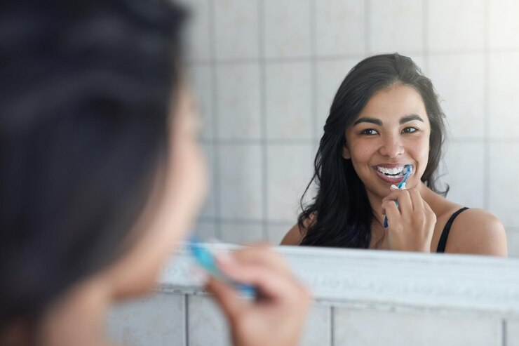 Photo taking care of her pearly whites shot of an attractive young woman brushing her teeth in the bathroom