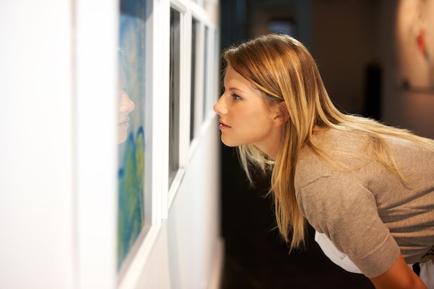 Un secolo d'arte inquadratura di una giovane donna che guarda i dipinti in una galleria