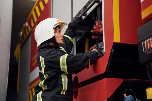 Фото Вывоз оборудования из грузовика женщина-пожарный в форме работает в отделении