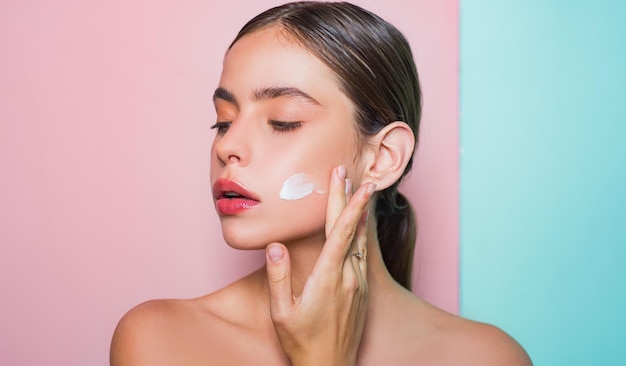 Taking good care of her skin beautiful woman spreading cream on her face skin cream concept facial care for female keep skin hydrated regularly moisturizing cream fresh healthy skin concept