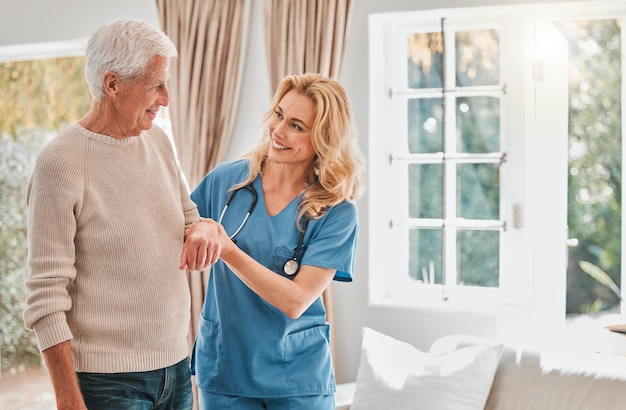 Taking it one step at a time Shot of a female nurse helping her elderly male patient