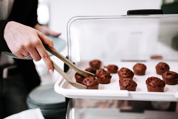 トングでマフィン菓子を撮る。