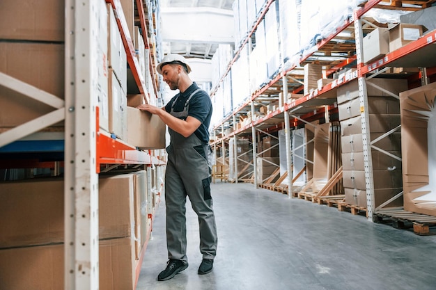 taking out the box employee in uniform is working in the storage at daytime