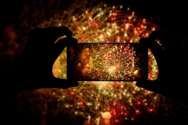 Taking the photo of fireworks via smartphone. Broadcast salute video to the internet.