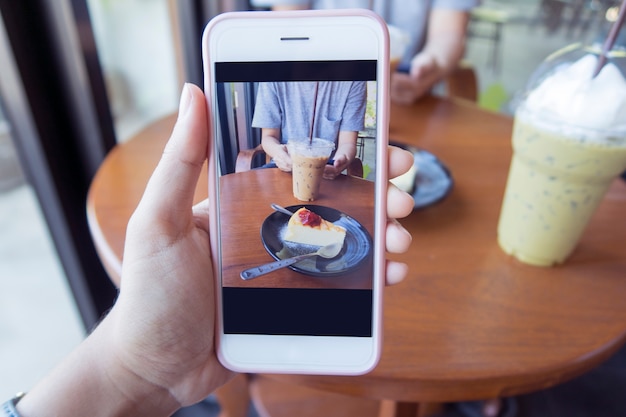 Taking photo of a piece of cake and a cup of coffee