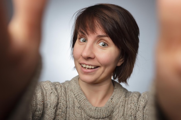 Taking picture Smiling cheerful girl with freckles doing selfie Stretching the hands to the camera