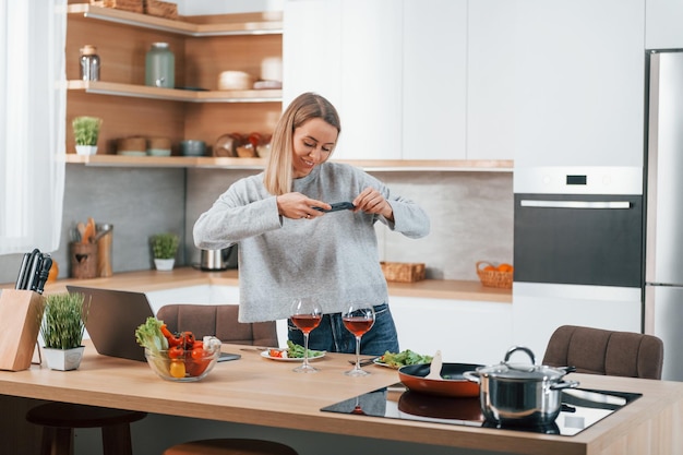 Photo taking pictures woman preparing food at home on the modern kitchen