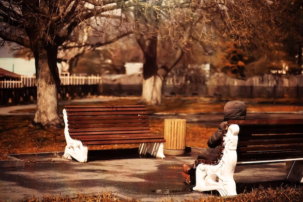 Taking a rest on a wooden bench in the park during autumn season