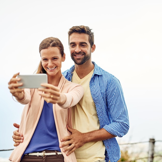 Taking a selfie on a beautiful day Cropped shot of an affectionate couple taking selfies outside