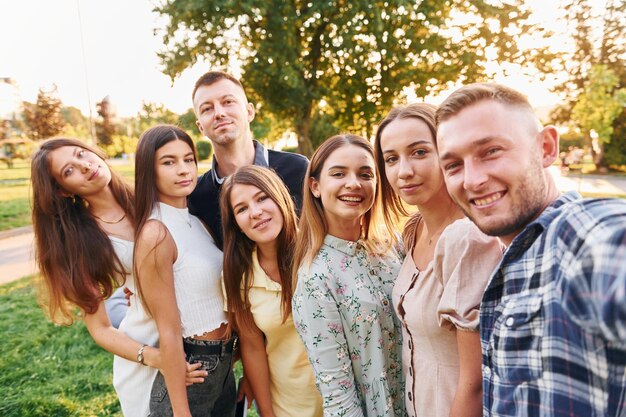 Photo taking a selfie group of young people have a party in the park at summer daytime