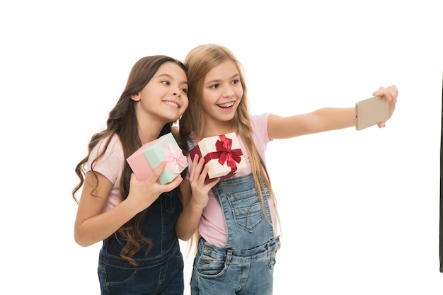Taking selfie How make professional unboxing Girls cute kids shooting unboxing video on smartphone camera Video call Vlog online stream and channel Kid hold gift box Unboxing birthday gifts