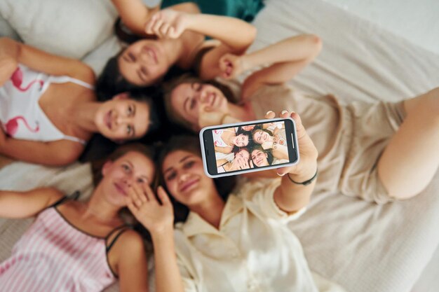 Taking selfie Top view of group of happy women that is at a bachelorette party