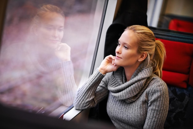 ストリーキングの風景を取り入れて電車で旅する魅力的な若い女性のクロップドショット