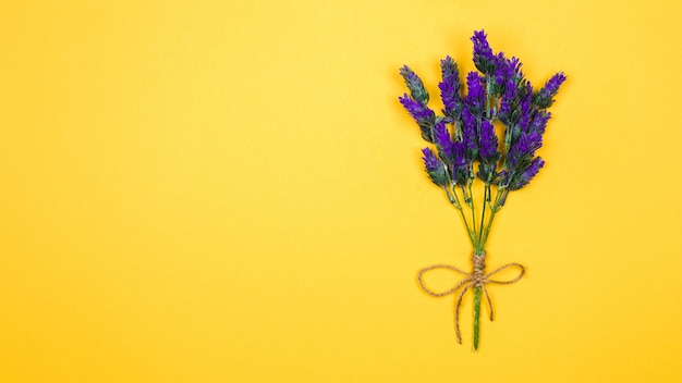 Takje van een lavendel bloem vastgebonden met een draad en strik op geel