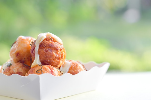 Takoyaki in witte kartondoos. Japanse snack gemaakt van een tarwebloem.