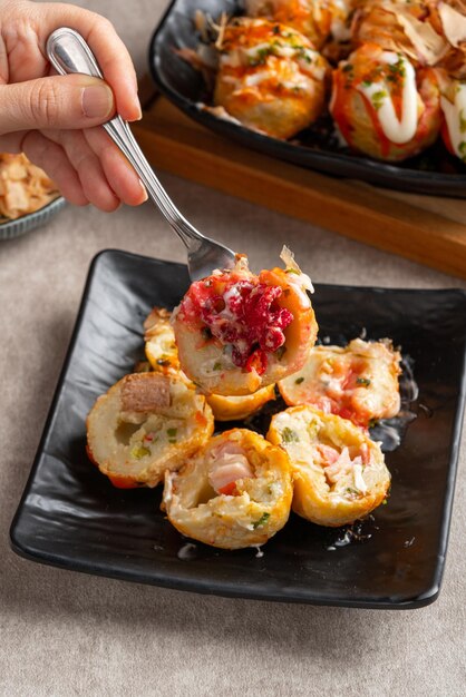 Foto il takoyaki è uno snack giapponese a forma di palla, composto da una pastella a base di farina di frumento e cotto in una speciale padella modellata