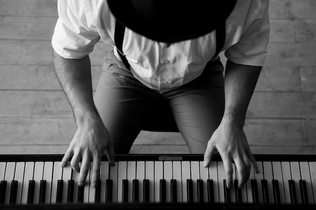 Photo talent and virtuosity. black and white top view image of man playing piano