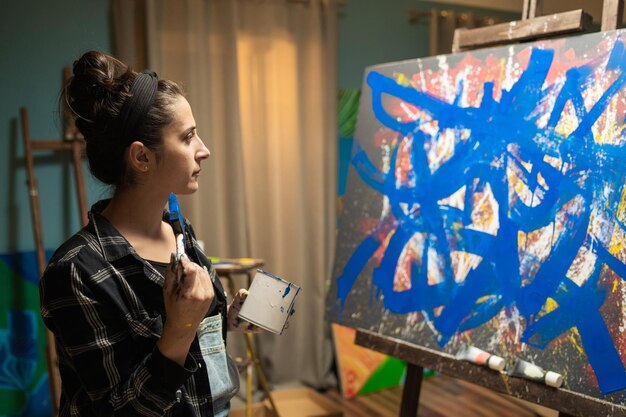 A talented artist works on an abstract oil painting