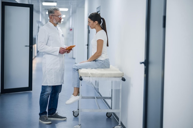 Talk with a patient Grayhaired doctor talking to the patient before MRI