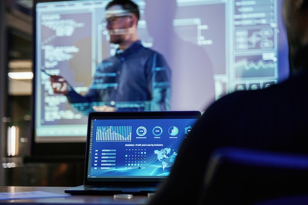 talking about project male business trainer is against projector with data teaching people