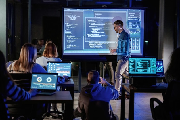 talking about project male business trainer is against projector with data teaching people
