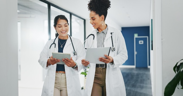 바쁜 병원에서 의사들이 걷거나 태블릿을 사용하여 수술 계획 의학 또는 생명 보험 앱을 위한 팀워크 또는 협력 기술 연구에 대해 행복한 미소를 짓거나 의료 여성을 계획하는 것